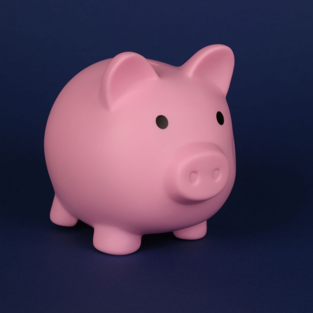 Charming close-up of a pink piggy bank set against a blue backdrop, perfect for finance concepts.